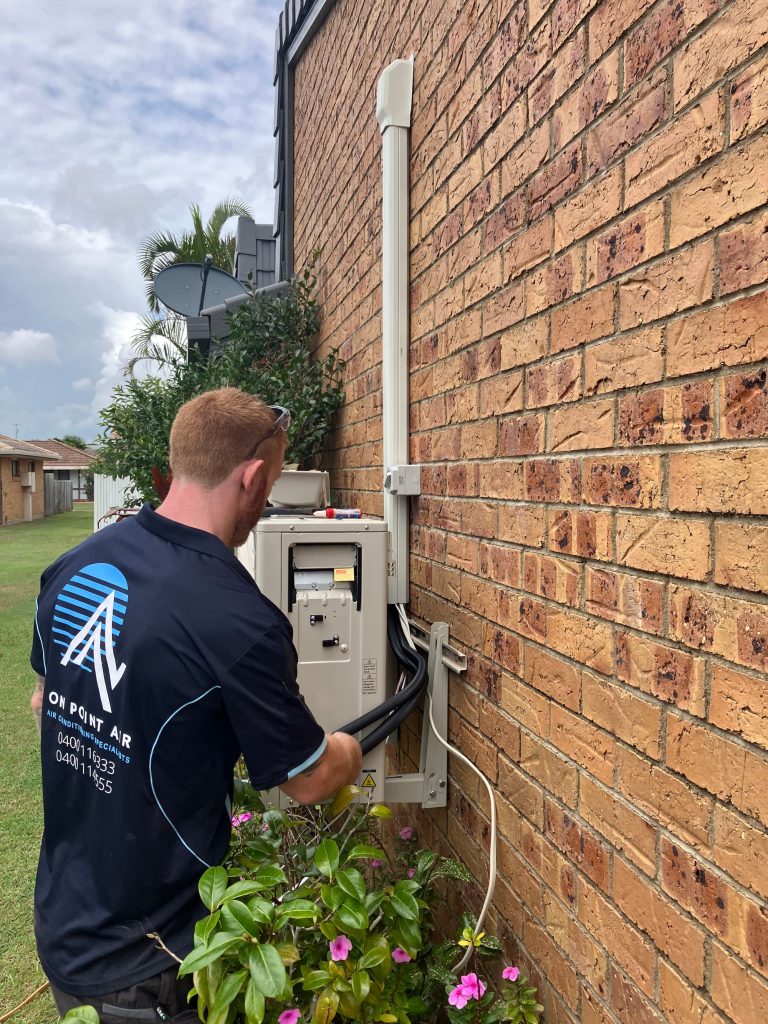 Commercial Air Conditioning - on point air team member fixing external unit